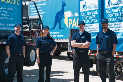 Uniformed Blue Kangaroo Packoutz team members standing in front of Blue Kangaroo Packoutz trucks