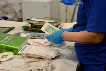 Blue Kangaroo Packoutz employee carefully cleans documents