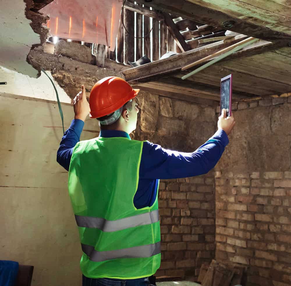 Worker inspecting damages roof