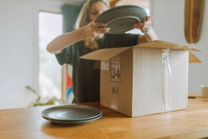 A woman unpacking plates from a box.