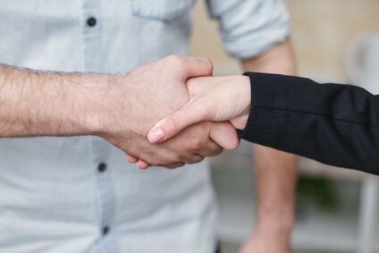 a male hand shaking a female hand.