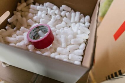 a box filled with packing peanuts and a roll of tape.